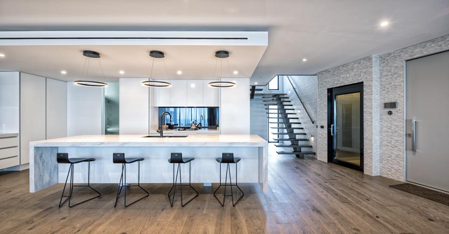 Modern kitchen with large island and staircase
