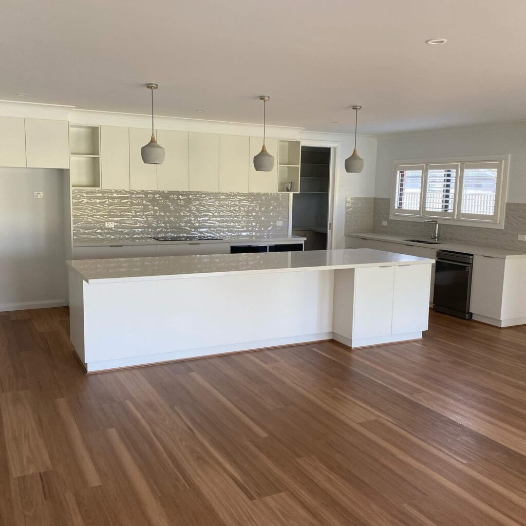 Modern white kitchen with island and timber flooring